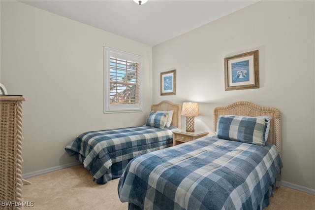 bedroom with baseboards and light colored carpet