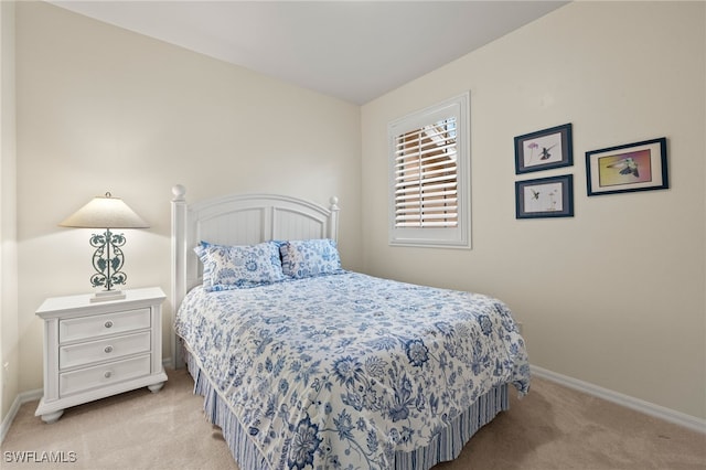 bedroom with light carpet and baseboards