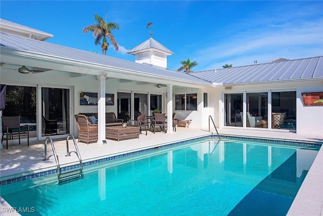 rear view of house with an outdoor pool, a patio, an outdoor hangout area, and metal roof