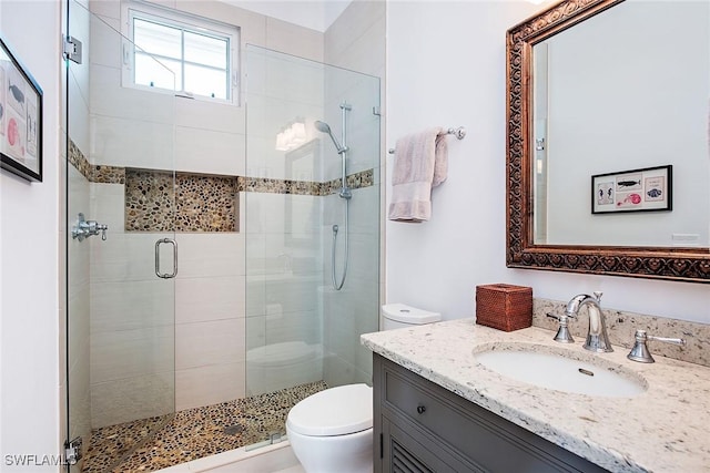 bathroom featuring a stall shower, vanity, and toilet