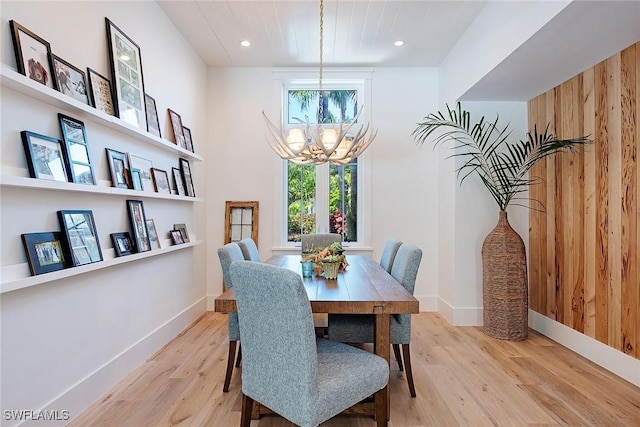 dining space featuring recessed lighting, a notable chandelier, baseboards, and wood finished floors