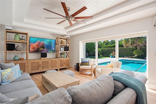 living room with baseboards, a raised ceiling, wooden ceiling, ceiling fan, and light wood-type flooring