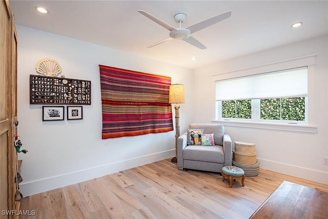 sitting room featuring baseboards, wood finished floors, and recessed lighting