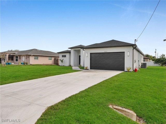 prairie-style home featuring a garage, concrete driveway, a front lawn, and stucco siding