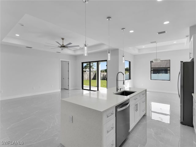 kitchen featuring white cabinetry, a tray ceiling, stainless steel appliances, and open floor plan