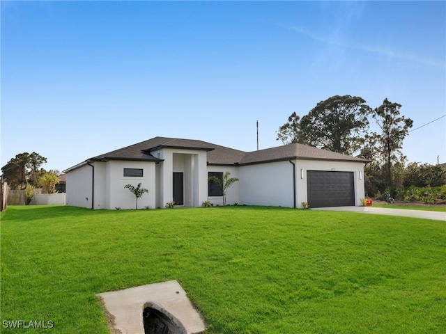 prairie-style house featuring stucco siding, concrete driveway, a front yard, fence, and a garage