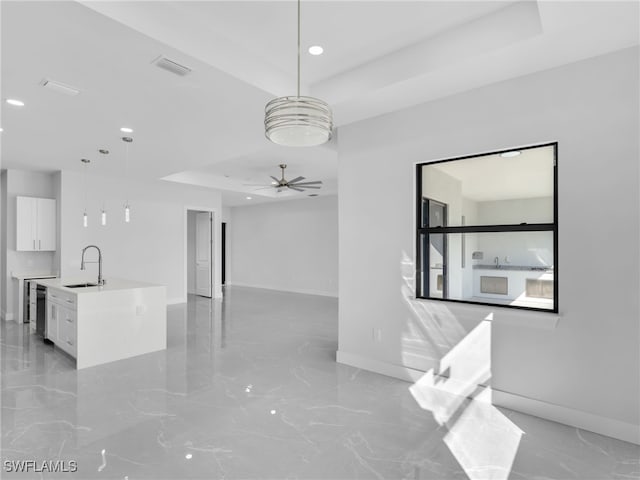 unfurnished room with a ceiling fan, a raised ceiling, visible vents, and a sink