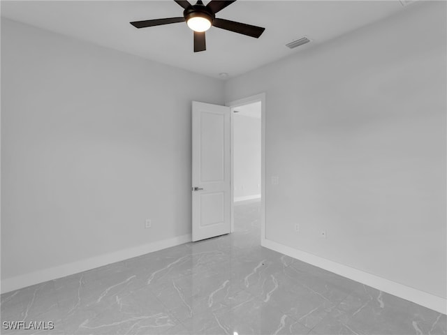 unfurnished room with marble finish floor, baseboards, visible vents, and ceiling fan