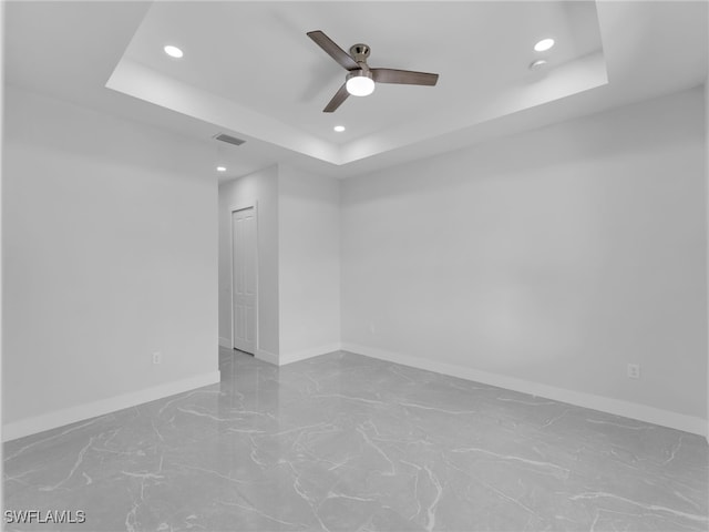 empty room featuring baseboards, a raised ceiling, a ceiling fan, and recessed lighting