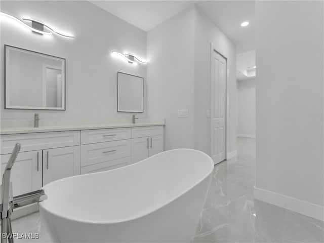 full bathroom with a sink, a freestanding bath, marble finish floor, a closet, and double vanity