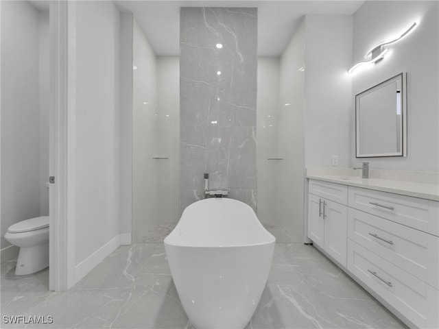 bathroom with toilet, marble finish floor, vanity, and a soaking tub