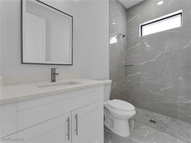 bathroom featuring marble finish floor, toilet, vanity, and a marble finish shower