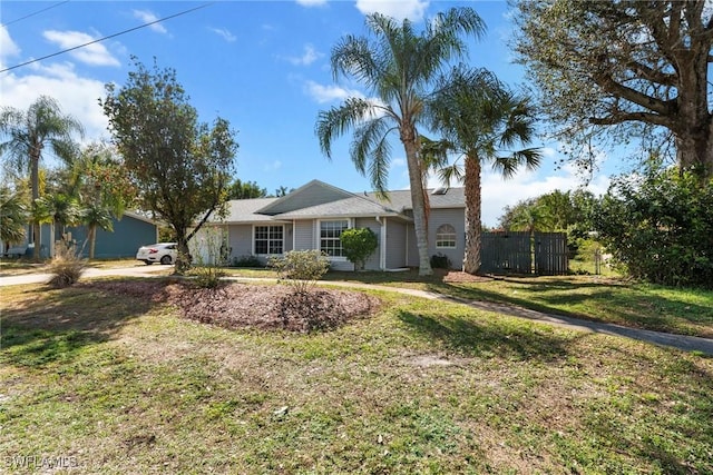 ranch-style home with a front yard and fence