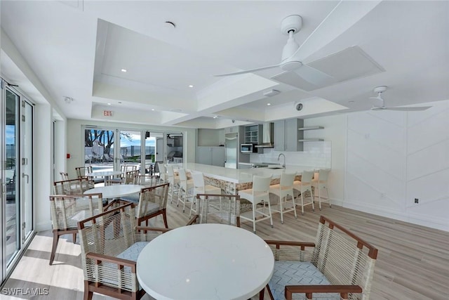 dining area with recessed lighting, a tray ceiling, ceiling fan, and light wood finished floors