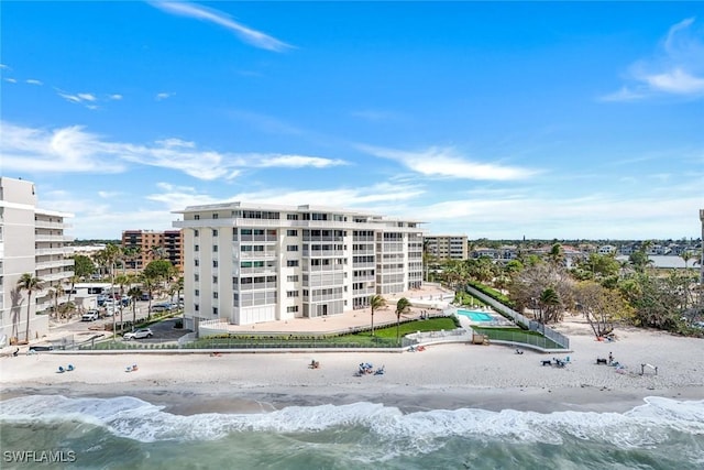 view of property featuring a water view, a view of the beach, and a city view