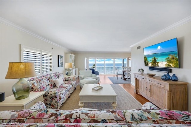 living area with wood finished floors and crown molding