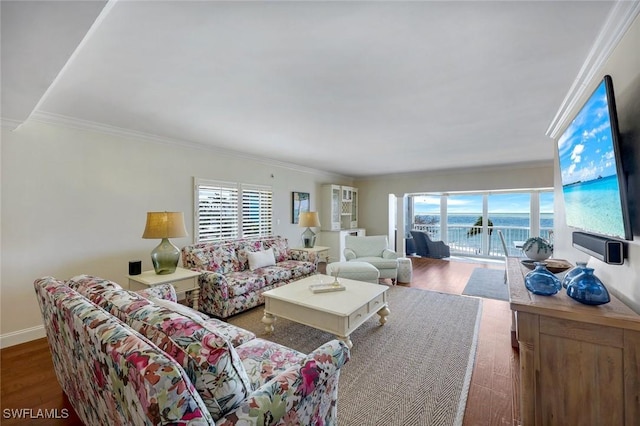 living area with baseboards, wood finished floors, and crown molding