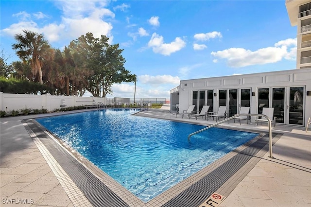 pool with fence and a patio