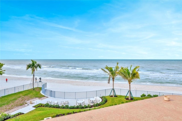 view of water feature featuring a beach view and fence