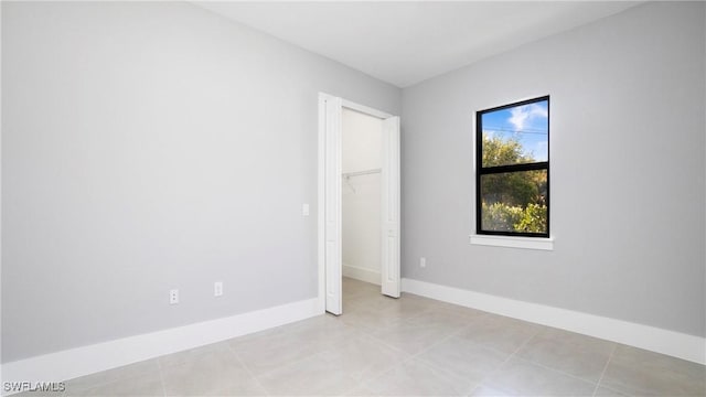 empty room featuring light tile patterned floors and baseboards