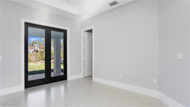 spare room with visible vents, french doors, and baseboards