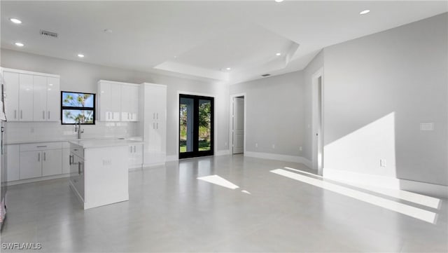 kitchen with a kitchen island, recessed lighting, white cabinets, modern cabinets, and tasteful backsplash