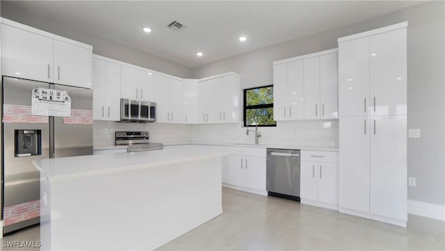 kitchen featuring white cabinetry, light countertops, appliances with stainless steel finishes, and a sink