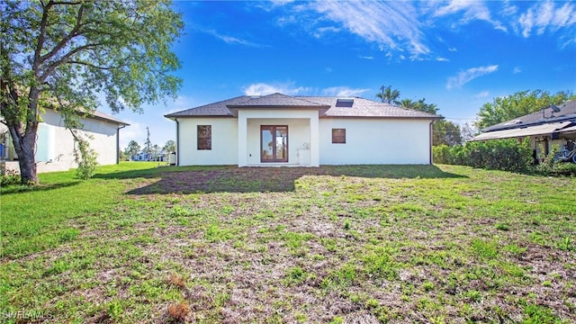 back of property featuring stucco siding and a lawn