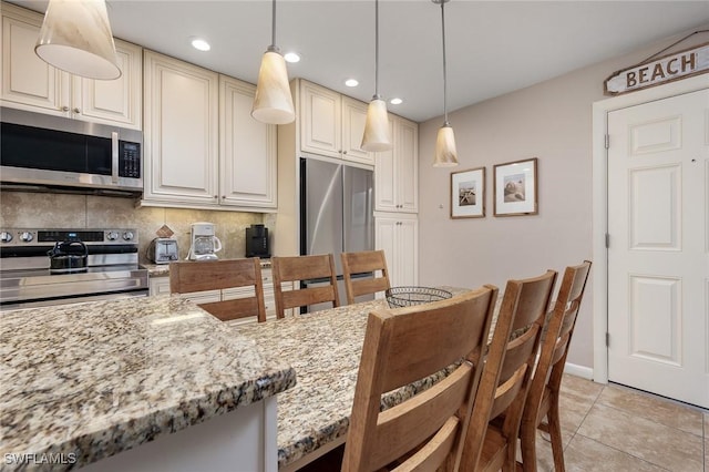 845 E Gulf Dr Unit 232, Sanibel, FL 33957 - kitchen with light stone countertops, light tile patterned floors, appliances with stainless steel finishes, and decorative backsplash