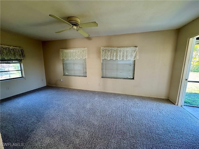 carpeted empty room with ceiling fan and baseboards