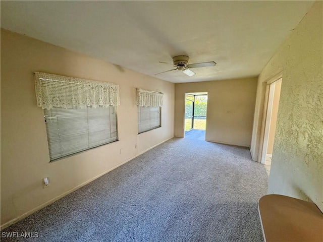 empty room featuring ceiling fan, carpet flooring, and baseboards