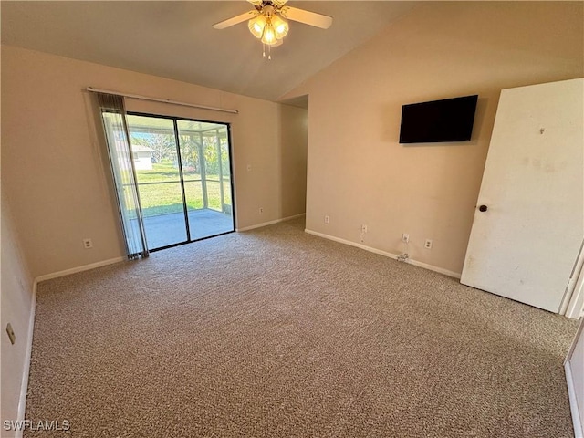 carpeted spare room with baseboards, vaulted ceiling, and a ceiling fan