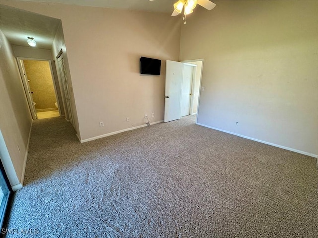 unfurnished bedroom with high vaulted ceiling, carpet flooring, a ceiling fan, and baseboards