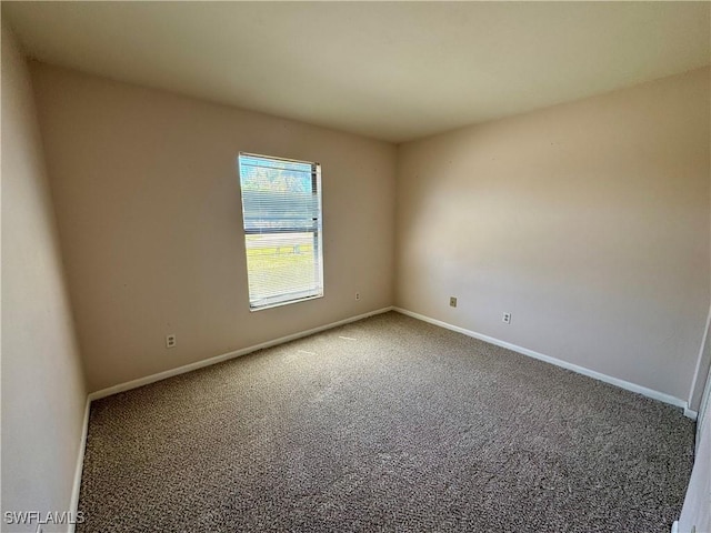 carpeted empty room with baseboards