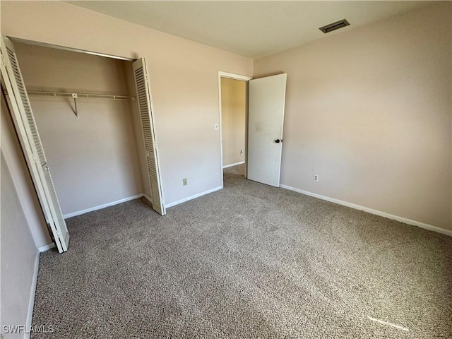 unfurnished bedroom with carpet floors, a closet, visible vents, and baseboards