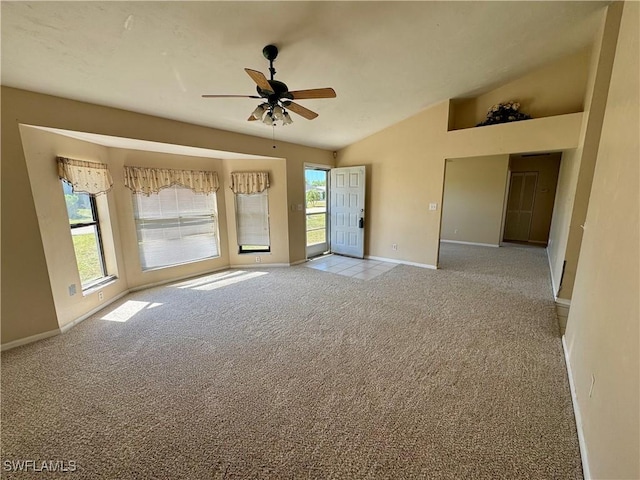 empty room featuring ceiling fan, baseboards, vaulted ceiling, and carpet flooring