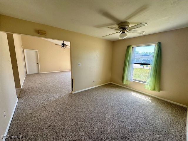 spare room with carpet, a ceiling fan, and baseboards