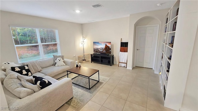 living area with light tile patterned floors, arched walkways, visible vents, and recessed lighting