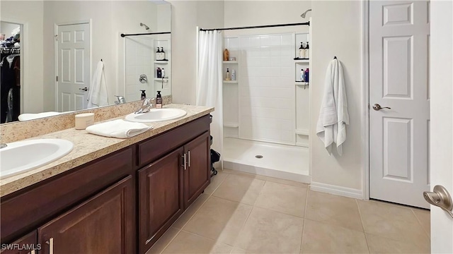 full bath featuring a walk in closet, a sink, a shower stall, and tile patterned floors