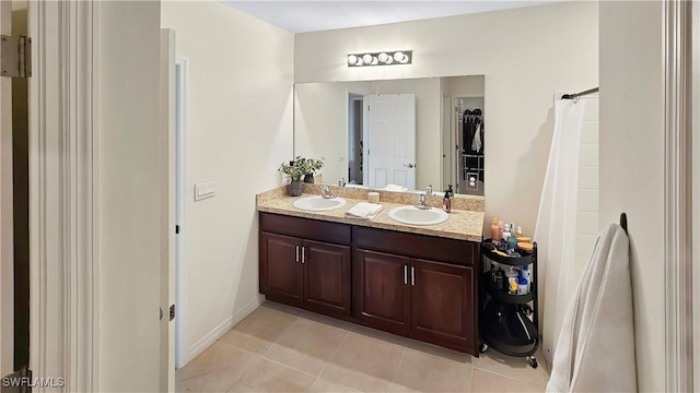 bathroom with double vanity, a sink, and tile patterned floors