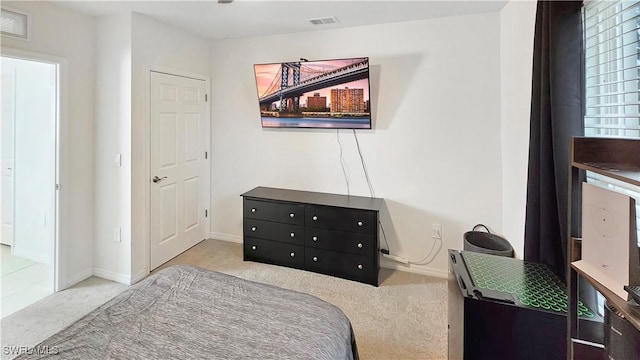 bedroom featuring baseboards, visible vents, and light colored carpet