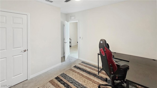 office area with baseboards, a ceiling fan, visible vents, and light colored carpet