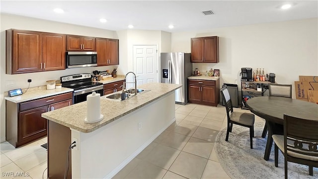 kitchen featuring light countertops, visible vents, appliances with stainless steel finishes, a sink, and an island with sink