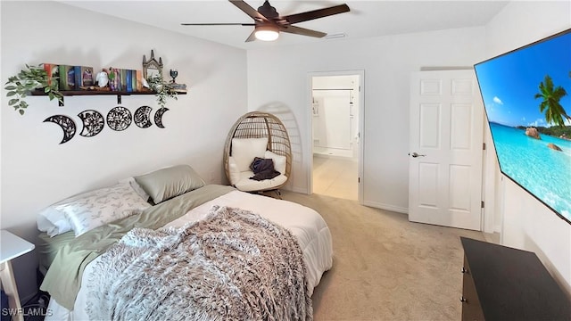 bedroom with light carpet, ceiling fan, and ensuite bathroom