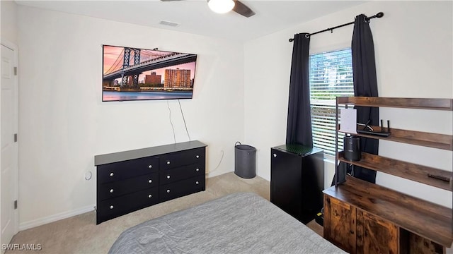 bedroom with light carpet, baseboards, visible vents, and a ceiling fan