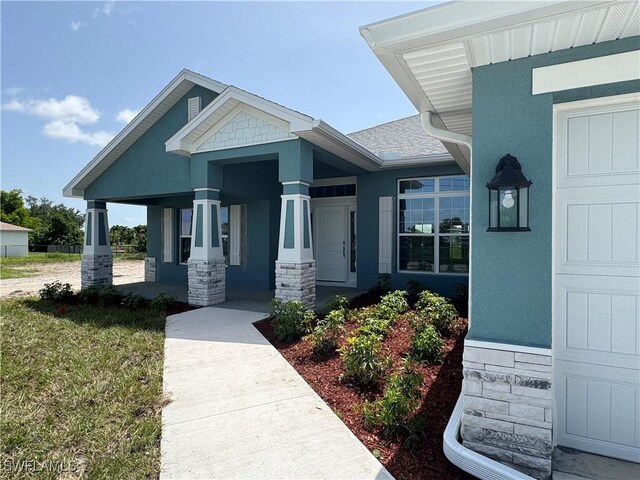 106 SE 5th Ave, Cape Coral, FL 33990 - doorway to property featuring a porch, stucco siding, and stone siding
