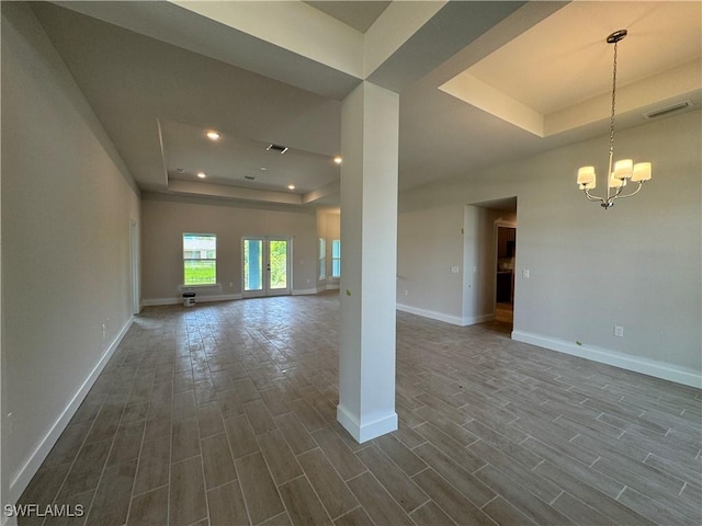 106 SE 5th Ave, Cape Coral, FL 33990 - unfurnished living room with a raised ceiling, dark wood-style floors, baseboards, a chandelier, and recessed lighting
