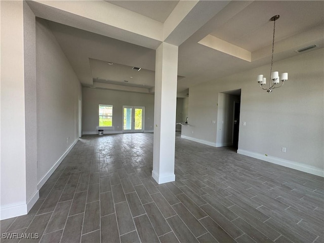 106 SE 5th Ave, Cape Coral, FL 33990 - spare room with a tray ceiling, dark wood-type flooring, a chandelier, and baseboards