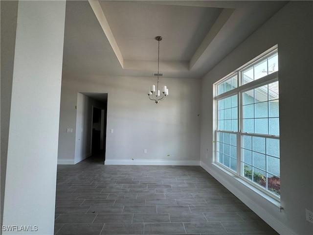 106 SE 5th Ave, Cape Coral, FL 33990 - unfurnished room featuring a tray ceiling, plenty of natural light, baseboards, and a chandelier