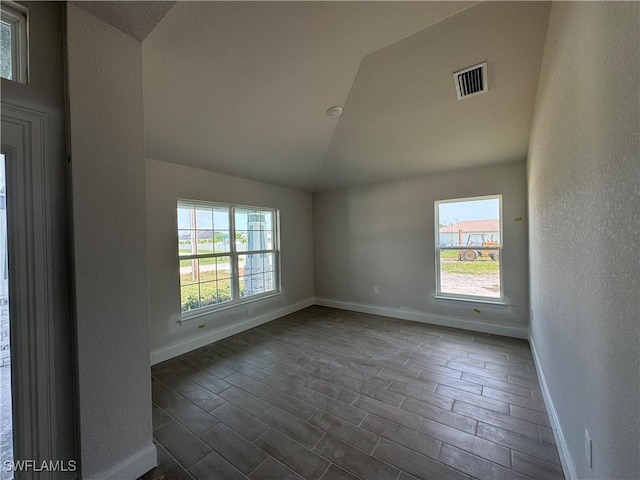 106 SE 5th Ave, Cape Coral, FL 33990 - spare room featuring vaulted ceiling, baseboards, plenty of natural light, wood finish floors, and a textured wall